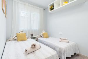 two beds in a room with white walls and yellow pillows at SUNNY SWEET HOME OLGA in Torrevieja +116 photos