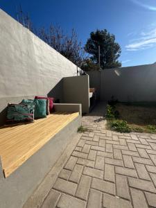 a bench with two pillows on it next to a wall at Duplex premium in La Porteña
