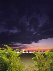 a cloudy sky over a body of water with trees at Vala Sea Breeze in Draçi