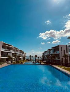 a swimming pool in front of some apartment buildings at Appartement de luxe front de mer in Tamaris
