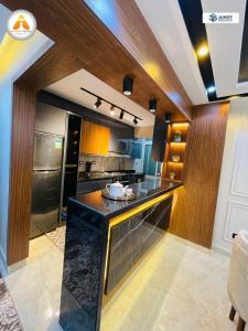 a kitchen with a black counter and wooden walls at Stylish & Trendy in Cairo
