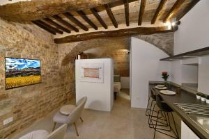 cocina con paredes de piedra, mesa y sillas en Auditorium Rooms, en Foligno 39 fotos más