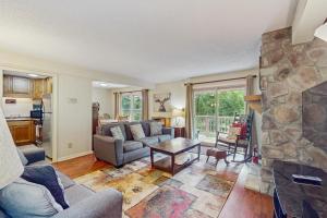a living room with a couch and a stone fireplace at Bee Branch 14 in Sugar Mountain