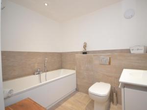 a bathroom with a tub and a toilet and a sink at 3 Bed in Westward Ho 40820 in Northam +14 photos