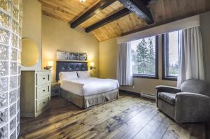 a bedroom with a bed and a chair and window at Auberge du Lac Taureau et Condos in Saint-Michel-des-Saints +209 photos