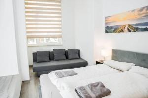 Un dormitorio blanco con dos camas y un sofá. en Central Cozy Home 2 Lübeck, en Lübeck