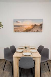 una mesa de madera con sillas y una pintura en la pared en Central Cozy Home 2 Lübeck, en Lübeck