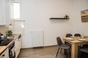 Una cocina con una mesa y sillas y un fregadero. en Central Cozy Home 2 Lübeck, en Lübeck