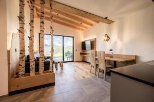 a kitchen and dining room with a desk and a dining table at Stabingerhof Chalets & Apartment-Farm stay in Bressanone