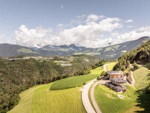 an aerial view of a house on a hill with a road at Stabingerhof Chalets & Apartment-Farm stay in Bressanone