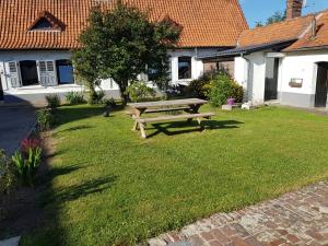 einen hölzernen Picknicktisch, der im Gras im Hof sitzt in der Unterkunft Entre Terre et Mer Le Haut Bois in Guisy