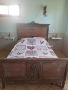 ein Bett mit einer Decke in einem Schlafzimmer in der Unterkunft Entre Terre et Mer Le Haut Bois in Guisy