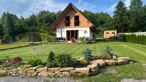 a small house with a yard with a stone wall at Evelin, Slovakia in Habovka