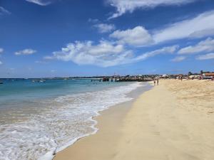 Una playa con gente caminando sobre la arena y el océano. en T0 Bounty, en Santa Maria