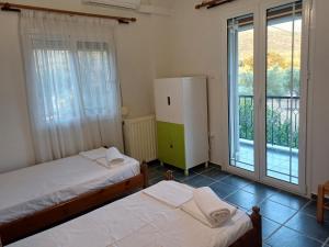 a bedroom with two beds and a large window at Yiannis & Ria's Farm in Kalamata