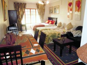 a living room with two beds and a couch at Petra's Country Guesthouse in Vryheid
