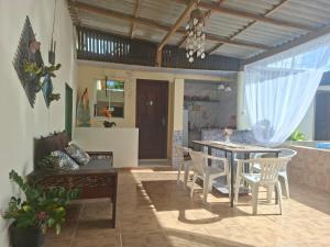 a dining room and living room with a table and chairs at Pousada Apolónia in Salinópolis