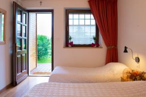 sypialnia z łóżkiem i oknem w obiekcie Bajta Fattoria Carsica w mieście Baita