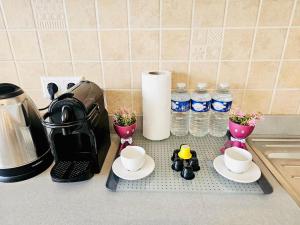 a kitchen counter with cups and flowers and water bottles at Chic 2BR easy access to the train station-2b in Luxembourg +2 photos