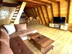 a living room with a couch and a tv and a table at Krushevski Konaci 3 in Kruševo
