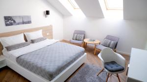 オラデアにあるCasa Mのベッドルーム1室(ベッド1台、椅子2脚付)