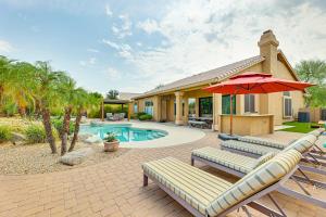 a house with a pool and a patio with chairs and an umbrella at Putting Green Golfers Getaway in Scottsdale in Scottsdale