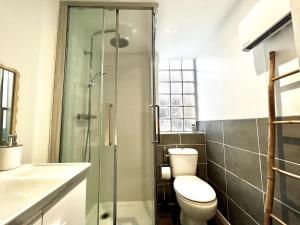a bathroom with a toilet and a glass shower at Appartement cosy à Hennebont ! in Hennebont