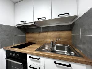 a kitchen with a sink and a stove at Appartement cosy à Hennebont ! in Hennebont