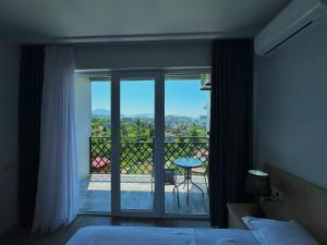 une chambre avec un lit et une vue sur un balcon dans l'établissement Green House - Studio Apartment with Mountain and Sea view, à Batoumi