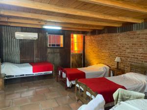 een slaapkamer met twee bedden en een bakstenen muur bij Posada Rio Tala in Río Tala +35 foto's