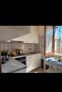 a kitchen with white cabinets and a table in it at Casa Da Rosa in Roseto degli Abruzzi