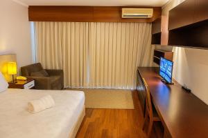 a hotel room with a bed and a desk with a computer at BOOK A FLAT Gran plaza Paulista in Sao Paulo