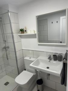 Un baño blanco con inodoro y lavabo. en Casa Olivia Oasis Duna, en Corralejo