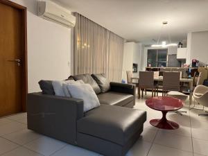a living room with a couch and a table at Cobertura com Piscina no Iloa in Barra de São Miguel