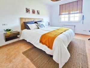a bedroom with a large white bed with a blanket at Casa Naveira vistas mar en Foz in Foz
