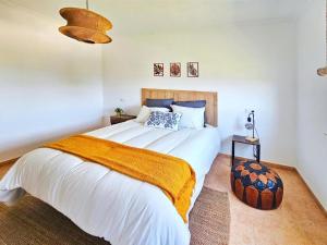 a bedroom with a large white bed with a orange blanket at Casa Naveira vistas mar en Foz in Foz +28 photos