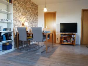 a dining room with a table and chairs and a television at Farm Ferienhof Albert in Teschendorf