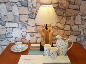 a table with a lamp and two cups on it at Farm Ferienhof Albert in Teschendorf +17 photos