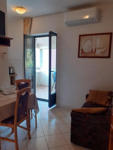 a living room with a table and a glass door at Calmaria Studio Apartments in Poreč
