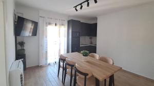 een keuken en eetkamer met een houten tafel en stoelen bij MarMeg Guesthouse in Tirana