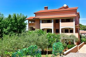 a house with a garden in front of it at Calmaria Studio Apartments in Poreč