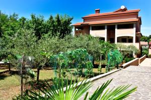 a garden in front of a house at Calmaria Studio Apartments in Poreč +5 photos