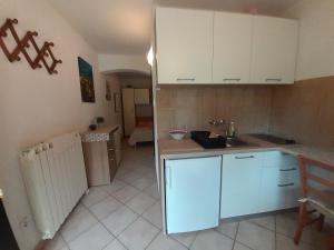 a kitchen with white cabinets and a counter top at Calmaria Studio Apartments in Poreč