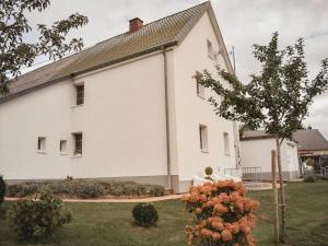 a white building with a tree in front of it at Country love -Holiday on the horse farm- in Frauenkron