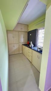 a large kitchen with white cabinets and black counter tops at Hill view residence in Visakhapatnam