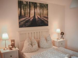 a bedroom with a bed with pillows and a painting on the wall at Country love -Holiday on the horse farm- in Frauenkron