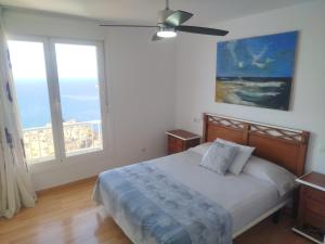 ein Schlafzimmer mit einem Bett und zwei großen Fenstern in der Unterkunft De la Montaña al Mar in Almería + 53 Fotos