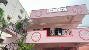 a pink building with windows and a balcony at Hill view residence in Visakhapatnam
