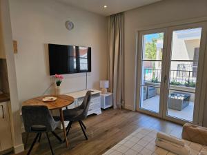 a living room with a table and a television at Lustica Bay Blue Horizon in Radovići