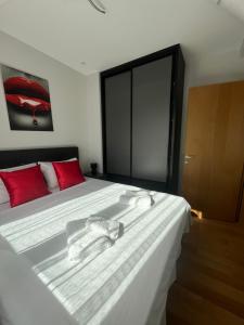a bedroom with a large white bed with red pillows at Valor in Zlatibor